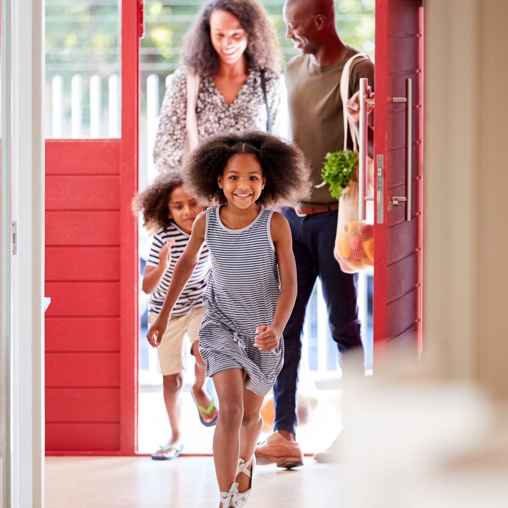 Happy family coming in their front door